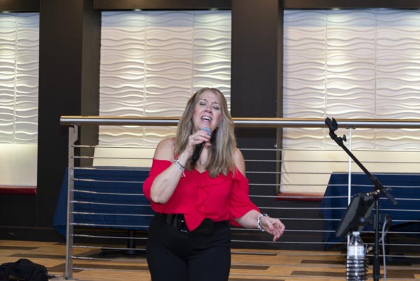 lady in red shirt on stage with microphone