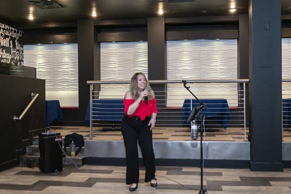 lady in red shirt on stage with microphone