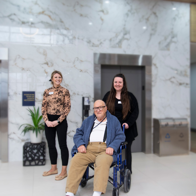 helpers and senior man in wheelchair