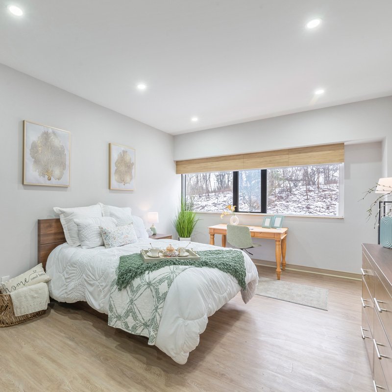 Stylish senior room with cozy bedding at Courtyard Luxury Senior Living