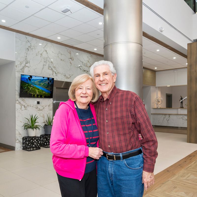 Senior people smiling in the Courtyard Luxury Senior Living lobby in Clinton, NJ
