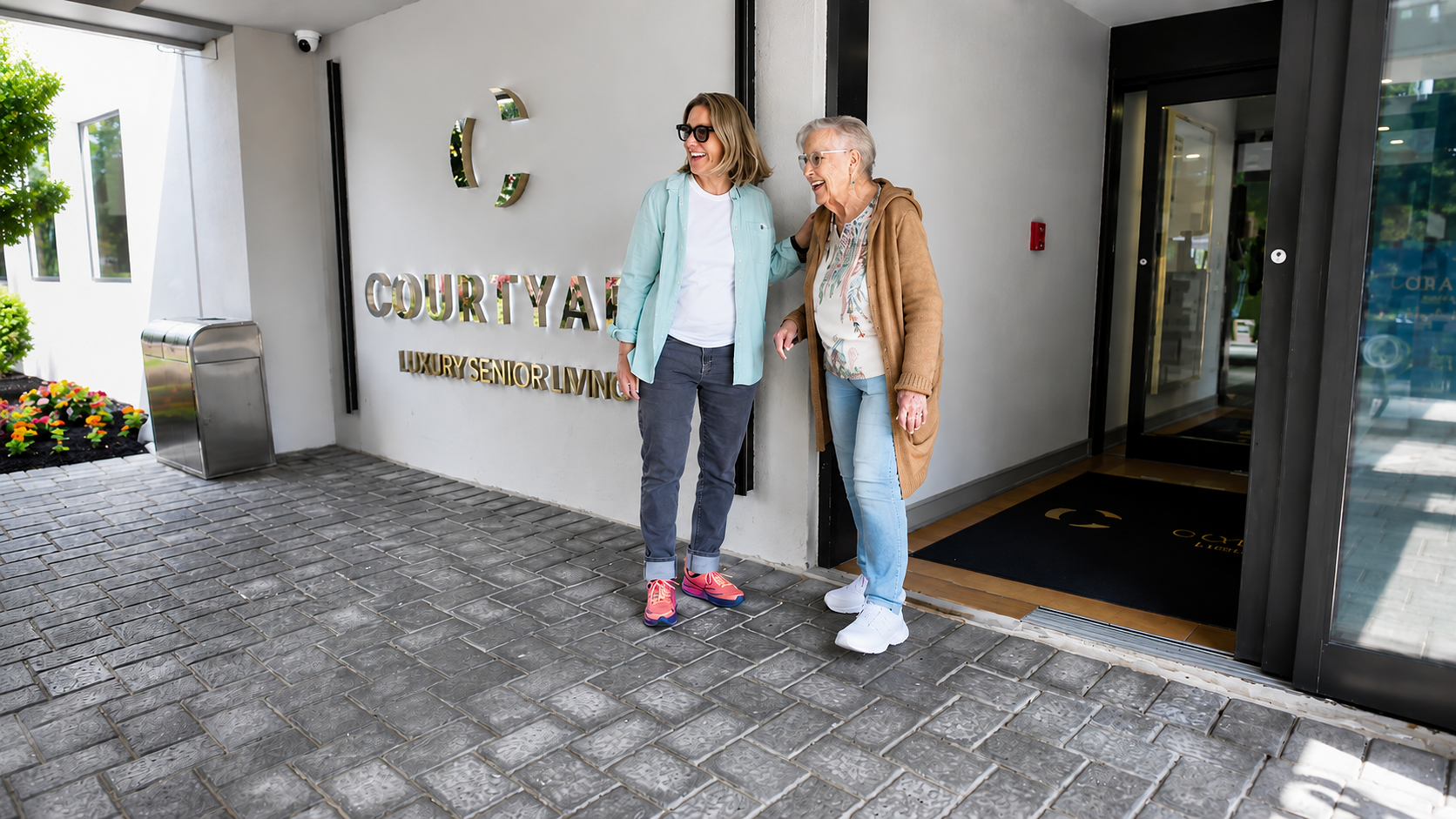 Family member visiting a resident at the Courtyard Luxury Senior Living entrance