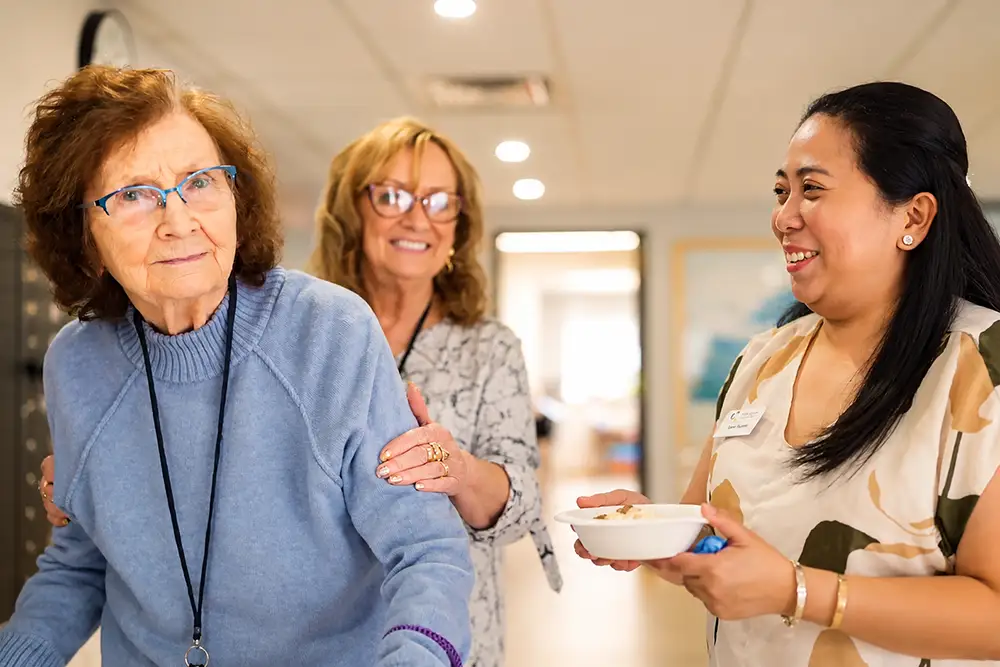 A resident with family and a Courtyard team member, smiling together