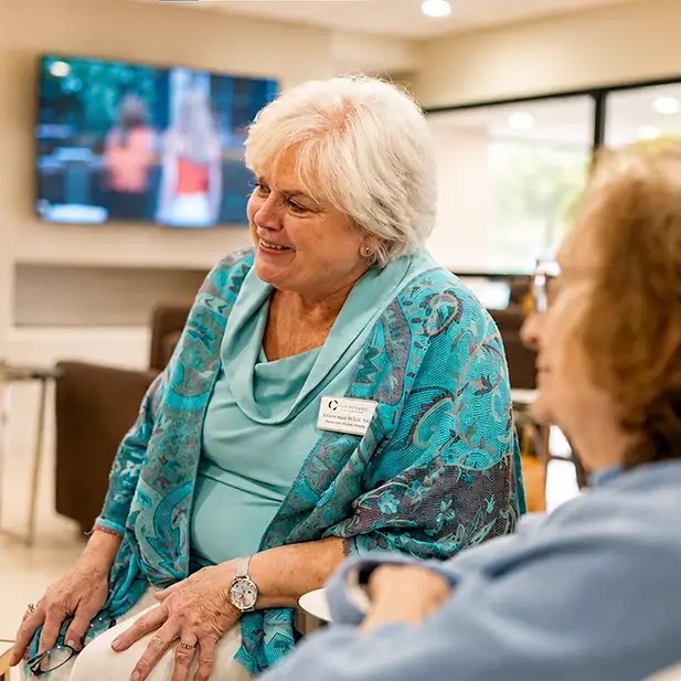 Two women chatting and smiling in the Courtyard lounge in Clinton, NJ